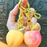 Peach Resin Keychain Pendant, glossy resin fruit bag charm with gold metal hardware